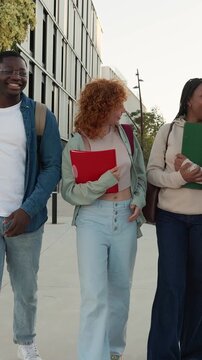 Diverse group of university students walking on campus together