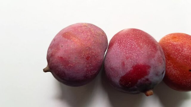 Three ripe red mango Mangifera indica fruits in a row isolated on white background
