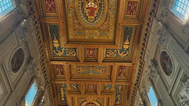 An incredible grand interior view showing the ornate golden ceiling, majestic marble columns, and exquisite religious artwork inside the historic Archbasilica of Saint John Lateran in Rome, Italy.

