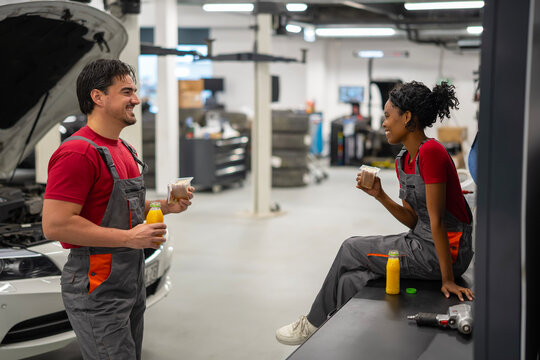 Mechanics taking a break enjoying conversation at auto repair shop