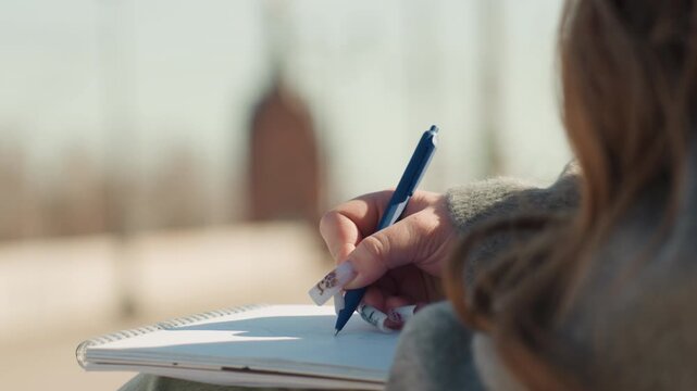 Closeup of writing process. Detailed view of handwriting with textured background and fingers. Precise depiction of hand writing notes with textured paper and artistic background elements
