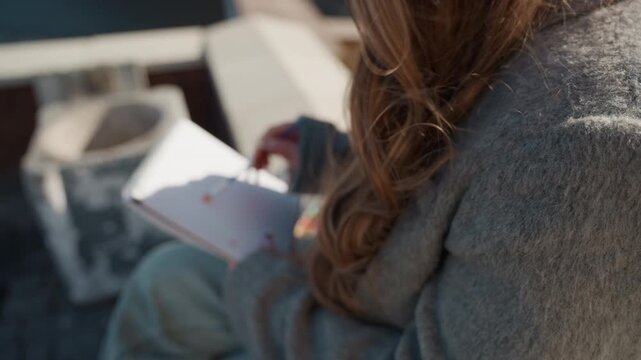 Artistic rooftop drawing. Sketching hands in journal scene. Closeup of hands creating on rooftop journal. Detailed depiction of hands and creative process on city rooftop during artwork creation