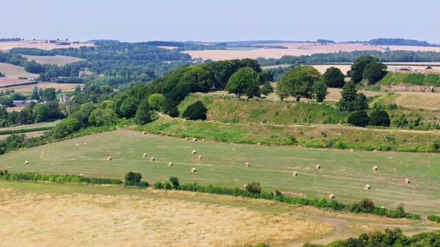 Telephoto tracking aerial shot of Old Sarum ramparts and historic hill fort, Salisbury, UK