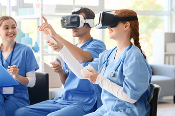 Medical students using virtual reality headsets and controllers during healthcare training simulation in classroom, nursing education with immersive technology and teamwork © Pixel-Shot