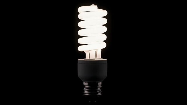 A single energy efficient compact fluorescent light bulb glows brightly, illuminating the darkness with its characteristic spiral shape and cool white light, symbolizing sustainability&nbsp;
