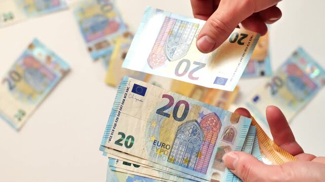 Income and Expenses in EU Countries. mans hands scatter Euro banknotes against a light background. Monetary Expenses, Costs, and Purchases.Salaries and Benefits in the European Union. 4k footage