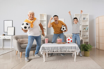 Little boy with his dad and grandfather watching football game at home © Pixel-Shot