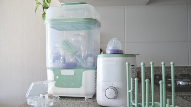 Baby bottle sterilizing machine and warmer appliance on a kitchen countertop for disinfecting