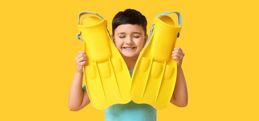 Cute little boy with flippers on yellow background © Pixel-Shot