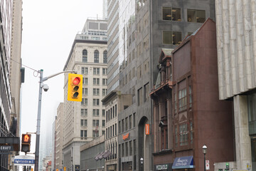 Naklejka premium varied architectural facades on Yonge St (looking southwest) from Adelaide St E on a cloudy fog overcast day, Toronto
