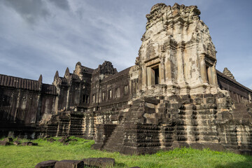Fototapeta premium Angkor Wat temple complex in Siem Reap, Cambodia, showcases intricate Khmer architecture and bas-reliefs under a cloudy sky, a testament to ancient artistry.