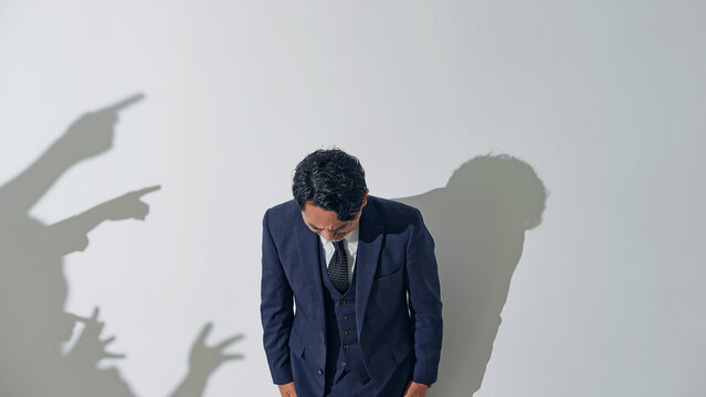 人々に批判される男性ビジネスパーソン