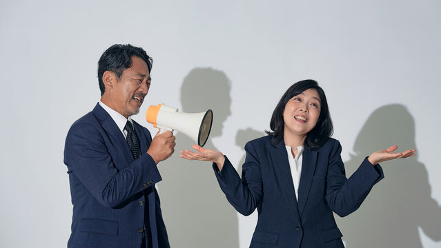 拡声器で女性に注意する男性ビジネスパーソン