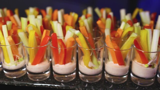 Vegan vegetarian snacks on decorated catering banquet table, with different salads, vegetable, cucumbers, pepper, carrot and celery sticks on corporate birthday party event or wedding reception 