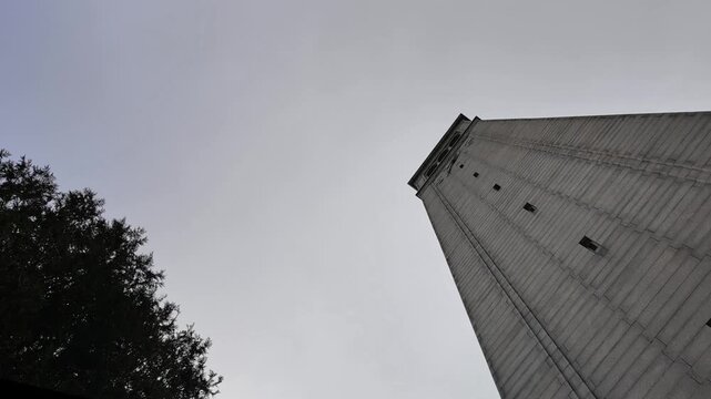 Low-angle view of the iconic Sather Tower, also known as The Campanile, on the University of California, Berkeley campus as clouds pass in the sky, representing education and knowledge
