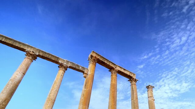 Daytime timelapse of ancient Roman columns under a moving cloudy sky in Jerash, Jordan. Archaeological site of Gerasa, historical Greco-Roman architecture and middle eastern heritage tourism