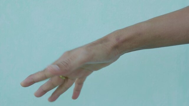 Woman exercise finger on blue wall background, massage muscle hand, ideas healthy lifestyle for elderly people, medical care good health concept.