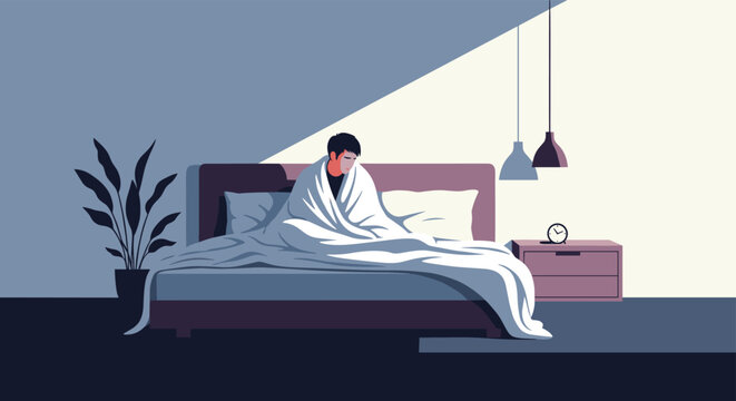 Young man feeling sad and exhausted while sitting up in bed wrapped in a blanket during the early morning hours in his bedroom.