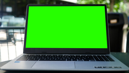 Fototapeta premium Timelapse of Green Screen Laptop in a Business Office Park Setting