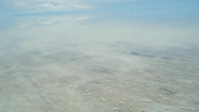 Hiking in boots on the Uyuni Salt Flat during the mirror effect in Potos&iacute;, Bolivia - vacation concept