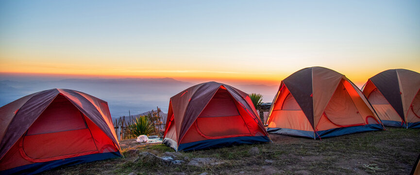 Banner Tent Camping trip outdoor hiking mountain hill. Tent camp in nature background sunrise top mountain. Adventure Travel with copy space. Banner Picnic tent green nature campground forest