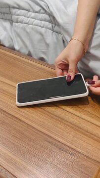 Plugging a smartphone into a charger, 9:16 vertical video, daily charging routine, battery power, connecting power cable, mobile technology, lifestyle.