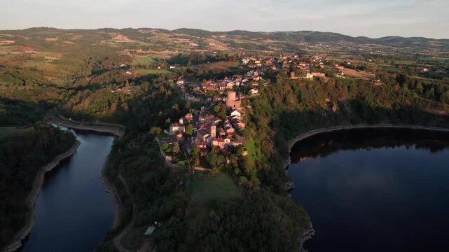 Aerial shot fyling toward Saint Jean Saint Maurice medieval tower at sunrise revealing the landscape and the Loire river, Loire departement, Auvergne Rhone Alpes region, France