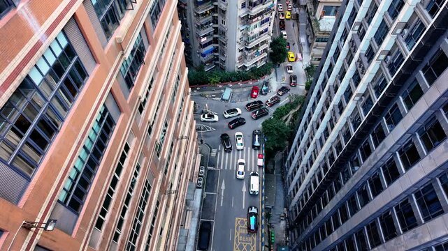 Upward panning aerial shot through dense urban canyon rising toward Kuixing Tower district in Chongqing, revealing the city's iconic multi-layered architecture where upper floors meet street level