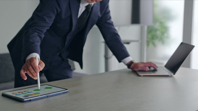 A man working using a laptop and a tablet PC.