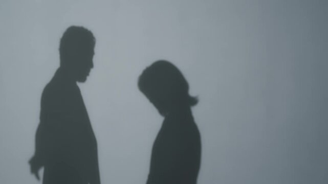 女性を叱る男性のシルエット