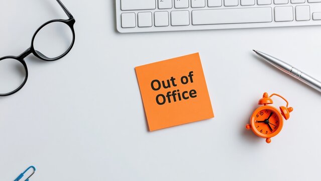 Office desk with out of office sticky note message for vacation and holiday work business
