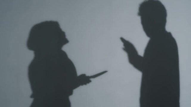 男性に刃物を突きつける女性のシルエット