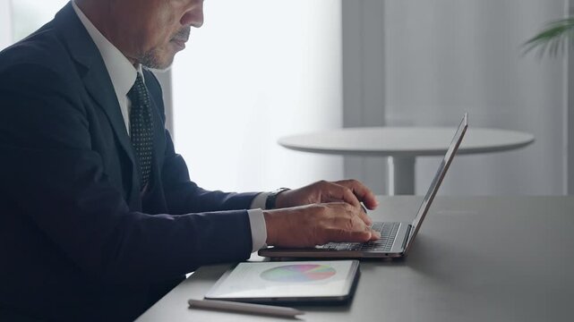 A man working using a laptop and a tablet PC.