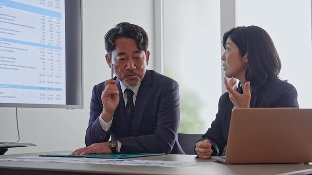 書類を見ながら会話するビジネスパーソンのグループ