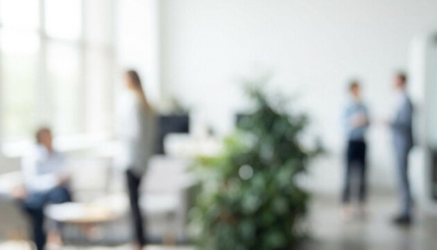 A blurred image of a modern office space showcasing people engaged in business discussions and interactions, creating a collaborative work environment.