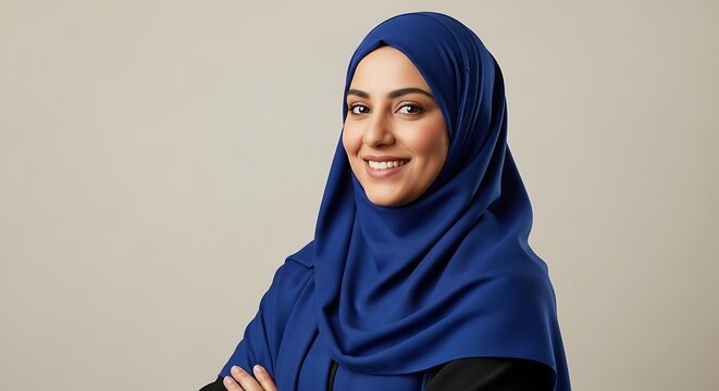 Confident Muslim woman in blue hijab, professional middle eastern female portrait, smiling arab business woman with crossed arms on studio background