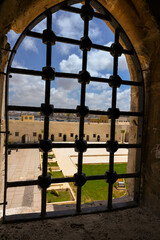 Obraz premium View of fortress grounds through an iron-barred fortified window at Qaitbay Citadel