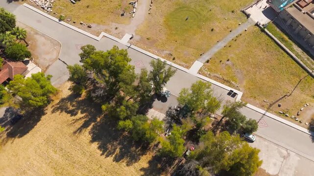 Balat, Turkey. Theatre of Miletus, monumental semi-circular stone cavea and ruined scaenae frons, aerial drone approach over green fields and golden grassland. Aerial View, MasterShots, Tilt up
