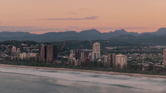 Oceanfront Skyline On Burleigh Heads Coastline At Sunrise. Queensland, Australia. aerial sideways shot