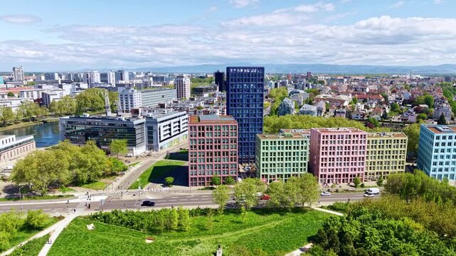 Aerial view of colorful modern office buildings by river and park on sunny day