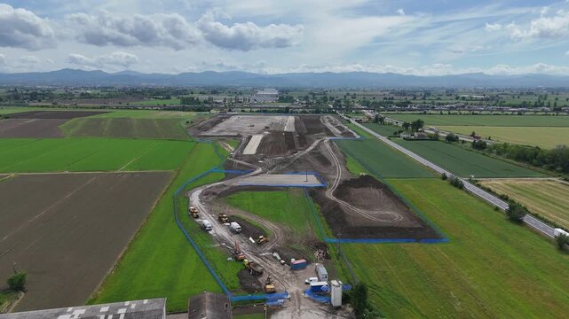 Large scale logistics and freight infrastructure development near the A1, A21 and SS9 junction in Fiorenzuola d'Arda, Emilia Romagna, Italy surrounded by cultivated Po Valley farmland and Apennines