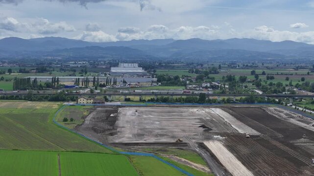 Large logistics park construction site near Fiorenzuola d'Arda, Emilia Romagna, Italy with active earthworks beside the A1 Autostrada del Sole, SS9 Via Emilia and A21 motorway junction, heavy freight