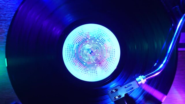 Spinning Vinyl Record on Turntable, Music Playback in Strobe Disco Lights, Top Down View