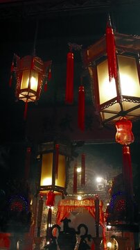 Ambient motion of glittering lights and rising incense smoke inside the ornate Lit Shing Kung in Man Mo temple decorated with red tassels and lamps for the Chinese New Year. Hong Kong