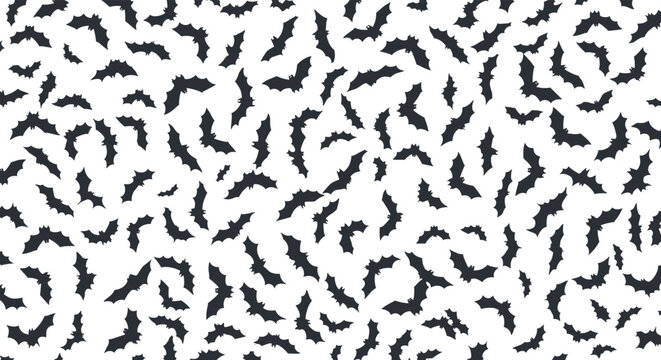 Seamless pattern of black bat silhouettes flying in various directions on white background creates a spooky halloween theme design.