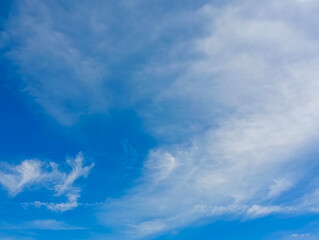 Fototapeta premium Soft white cloud formations spreading across a vivid blue sky, creating a calm natural background with atmospheric and weather concepts.