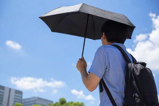 暑い日に日傘をさす男性