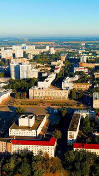 Vertical video. Oryol, Russia. The House of Soviets on Lenin Square, a monumental Soviet-era administrative complex with a long horizontal facade, Drone footage over the Orlik River embankment and ci