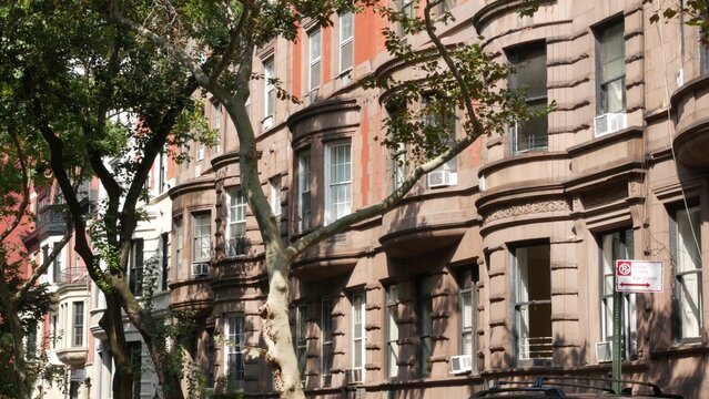 New York City townhouse buildings, brownstone row houses in Manhattan or Brooklyn, United States of America. Classic buildings on residential district street. Real estate property. Rowhouse townhome