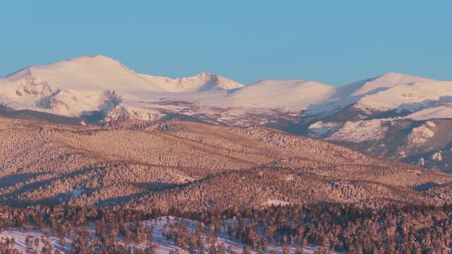 Majestic purple Front Range Rocky Mountains Mount Blue Sky Evergreen Colorado aerial drone springtime morning sunrise alpenglow snow Evergreen Meadows Mt Evans wilderness landscape landmark zoom in